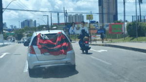 PRF flagra motorista com placa encoberta por bandeira e licenciamento vencido na BR-101 em Natal