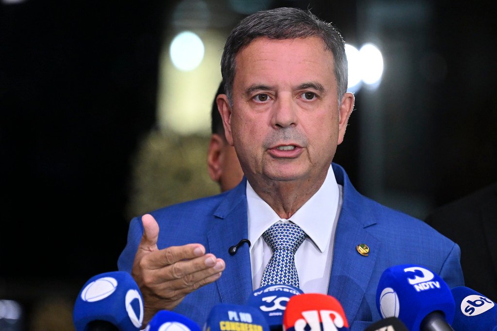 Rogério Marinho, de terno azul, fala a jornalistas diante de microfones no Senado.