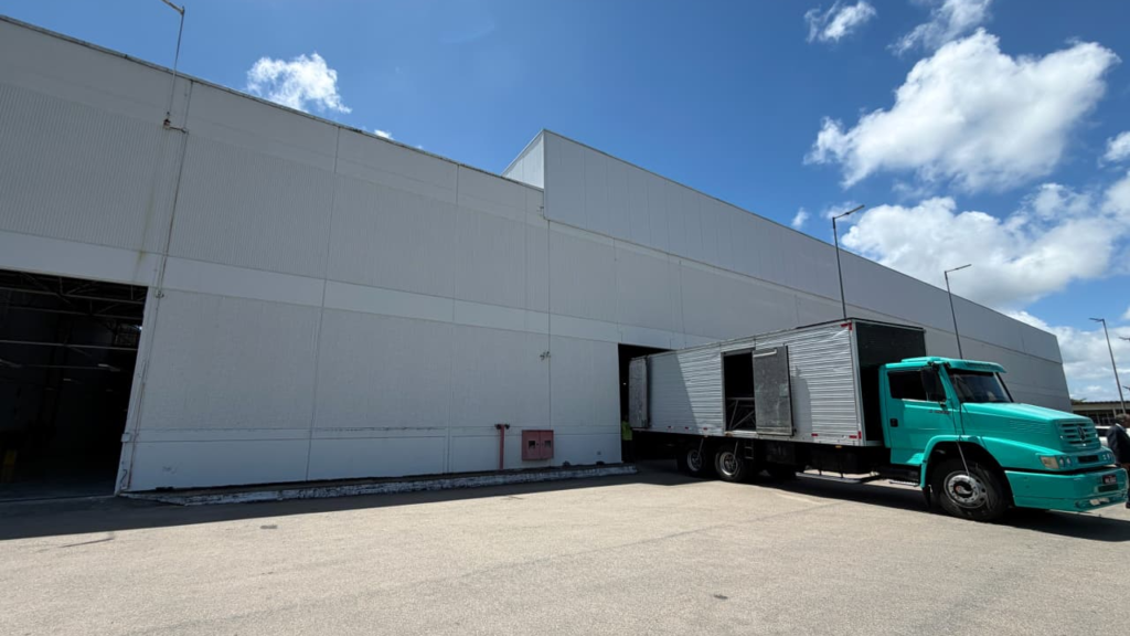 Fachada do galpão do novo centro de distribuição, com caminhão estacionado.