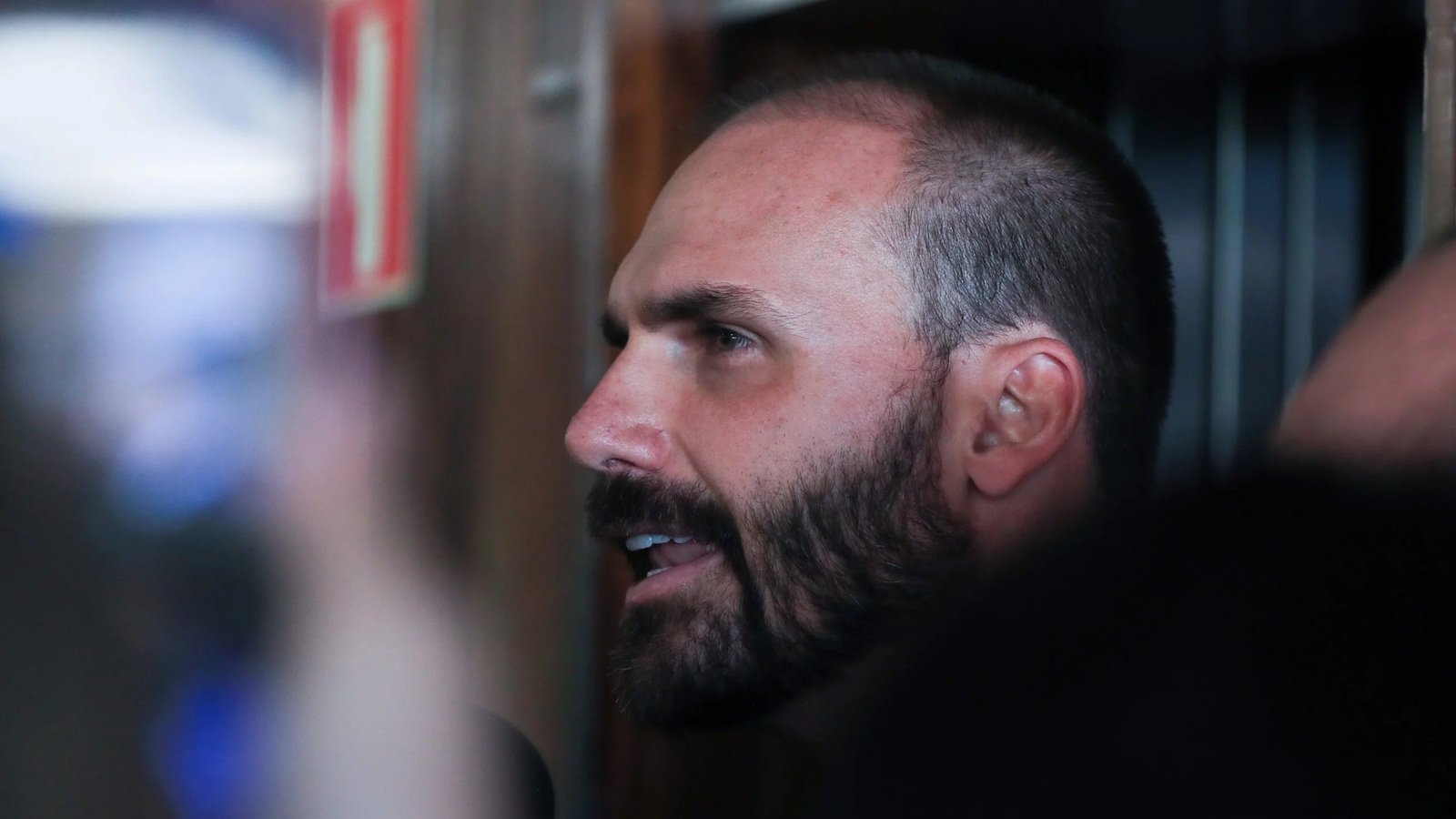 Eduardo Bolsonaro, de perfil, fala durante entrevista em fotografia de arquivo.